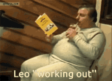 a man is reading a book while drinking a milkshake and the words leo " working out " are below him