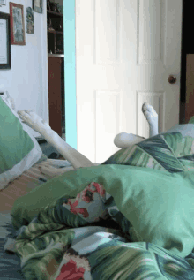 a person laying on a bed with green sheets