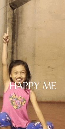 a little girl is sitting on the floor with her arm in the air and the words happy me written above her