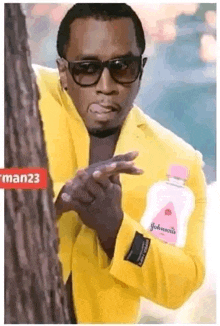 a man in a yellow suit is holding a bottle of baby lotion .