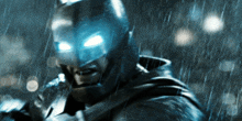 a close up of a person wearing a batman costume in the rain