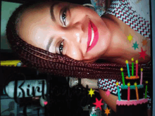 a woman with braids and a birthday cake with candles on it