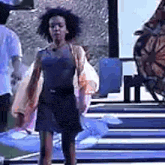a woman in a black dress is standing in front of a butterfly in a room .
