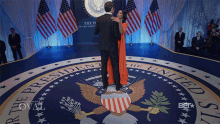 a man and woman are dancing in front of the seal of the president of the united states of america