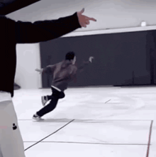a man is pointing at another man while ice skating on an ice rink .