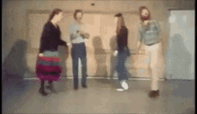 a group of people are standing in a room and talking to each other .