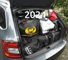 the trunk of a car is filled with luggage and a bag that says eagle-cryptian games