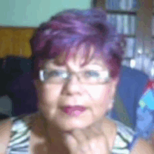 a woman with purple hair is wearing glasses