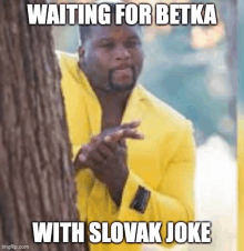 a man in a yellow jacket is peeking out from behind a tree and waiting for betka with slovak joke .