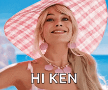 a woman wearing a pink hat and a necklace says hi ken .