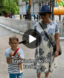 a woman is standing next to a young boy holding a toy gun with a caption that says szybki rdm