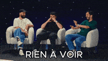 three men are sitting in chairs with the words rien a voir in the corner