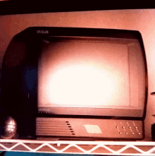 a black rca television is sitting on a metal rack