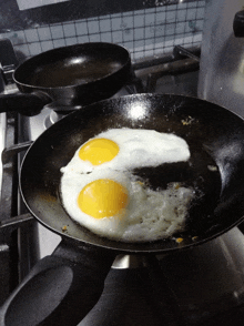 two eggs are cooking in a pan on a stove