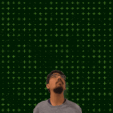 a man with glasses stands in front of a green background with the numbers 12 + 12