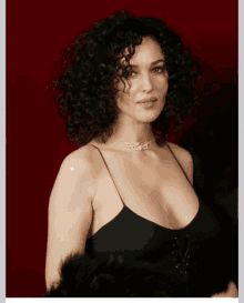 a woman with curly hair is wearing a black top