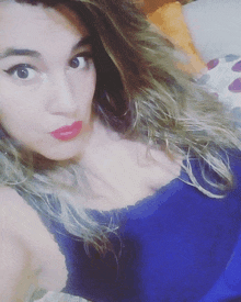 a woman with long hair is wearing a blue tank top and red lipstick