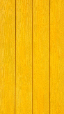 a close up of a yellow wooden wall texture .