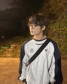 a young man wearing glasses and a sweatshirt that says center gear