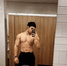 a shirtless man taking a selfie in a bathroom