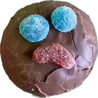 a chocolate cookie with blue and red gummy candies on it