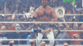 a wrestler holds up his aew heavyweight championship belt