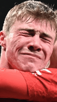 a close up of a man making a funny face with his eyes closed in a boxing ring .