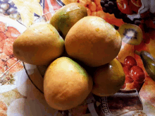 a bowl of mangoes sits on a table with a banana advertisement