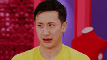 a man wearing a yellow shirt is crying with his mouth open .
