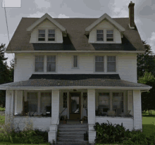 a white house with a porch and stairs