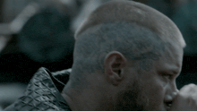 a man with a beard has a tattoo on his forehead that says ' ragnarok '