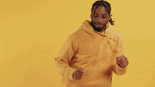 a man in a yellow hoodie is dancing and smiling