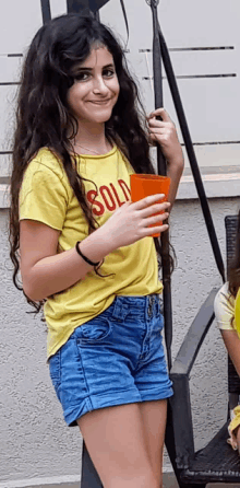 a young girl wearing a yellow shirt that says solo