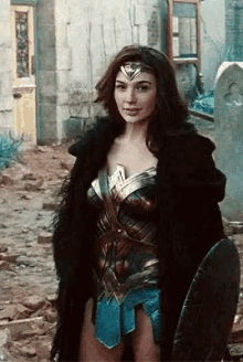 a woman in a wonder woman costume is holding a shield in her hand .