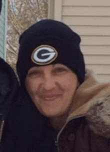 a man wearing a black beanie with a green bay packers logo on it .