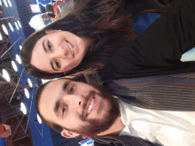 a man and woman are posing for a picture and smiling