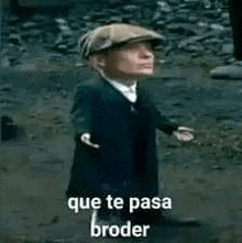 a little man in a suit and hat is standing in the dirt with the words `` que te pasa broder '' .