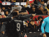 a soccer player wearing a black jersey with the number 9 on the back