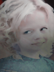 a close up of a child 's face with blonde hair