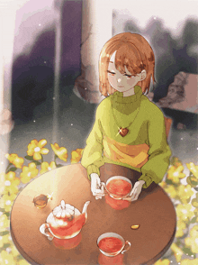 a girl in a green sweater sits at a table with a cup of tea and a teapot