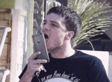 a man in a black shirt is talking on a cell phone