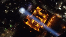 an aerial view of a building that is lit up at night