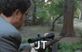 a man in a suit is holding a rifle with the word jt on it