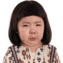 a little girl with short hair is making a funny face .