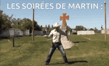 a man in a cowboy hat is dancing in front of a cross with the words les soirees de martin below him