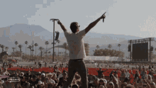 a man stands in front of a crowd with his arms in the air and a sign that says streaming