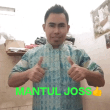 a man in a blue shirt is giving a thumbs up with the word mantul joss in green