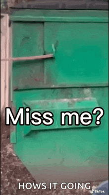 a green trash can with the words `` miss me ? '' written on it .