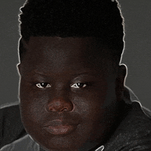 a close up of a young man 's face with a very dark skin .