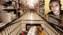 a man wearing headphones looks at a shopping cart full of food